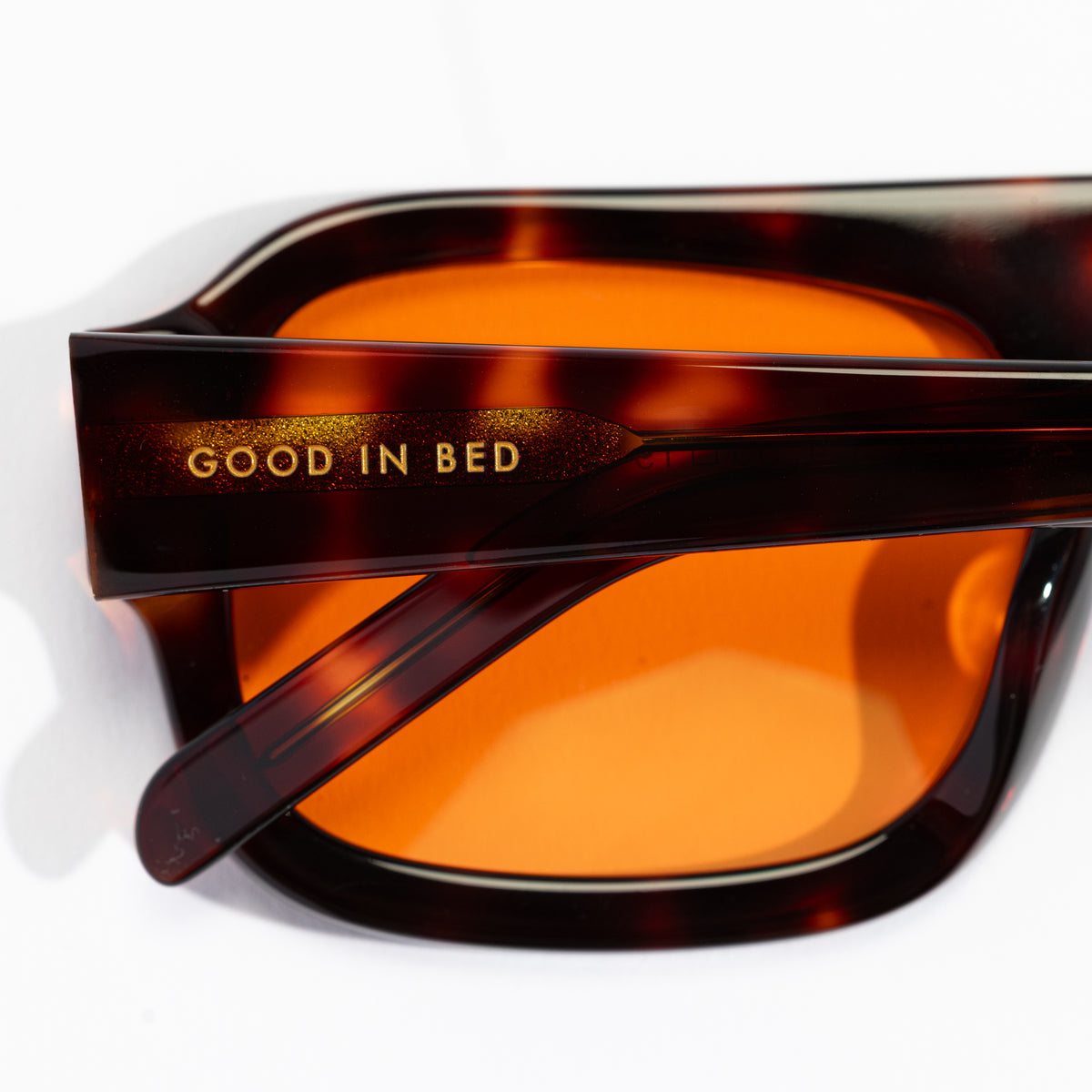 Close-up of Good In Bed DYLAN blue light blocking glasses Dark Tortoise frame showing brand name engraving on temple arm