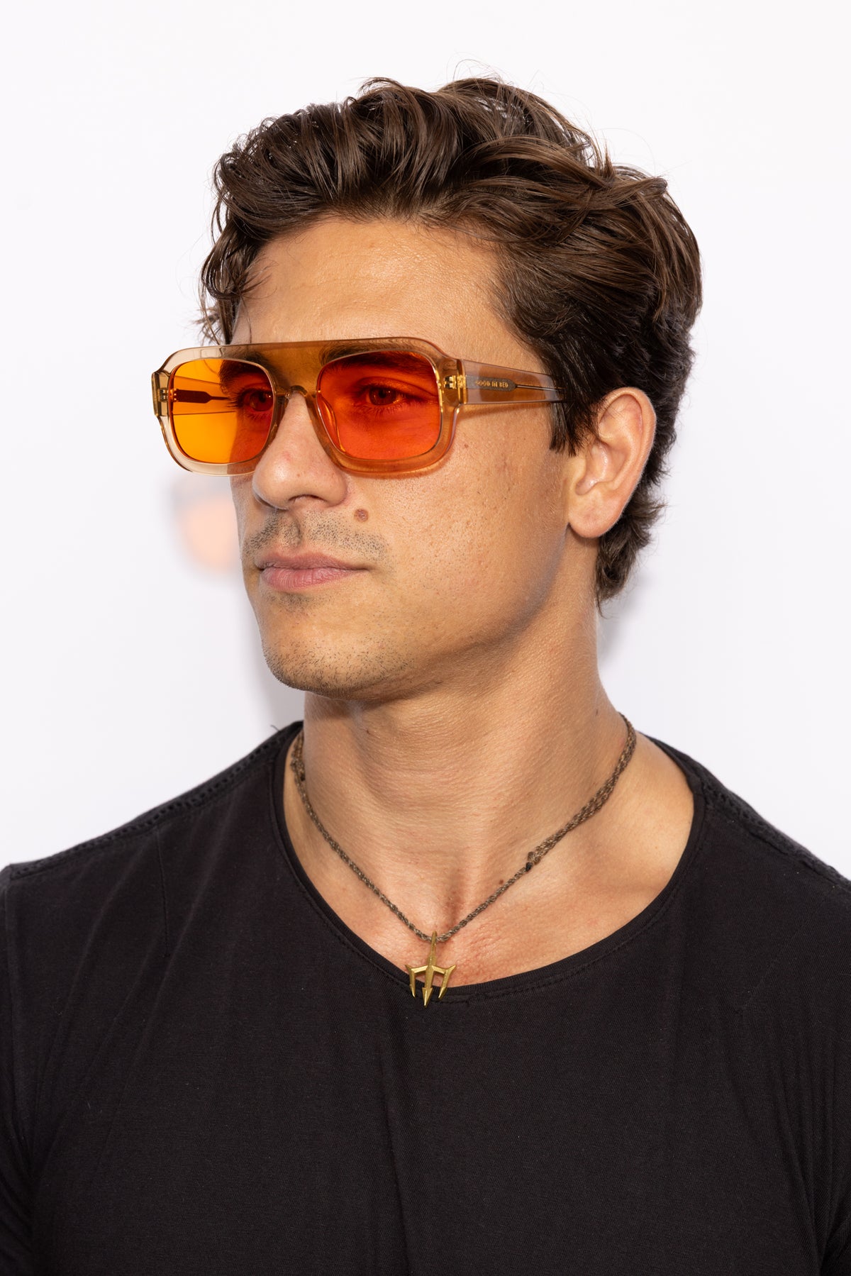 Man wearing Good In Bed DYLAN blue light blocking glasses in Translucent Honey, 3/4 profile lifestyle shot