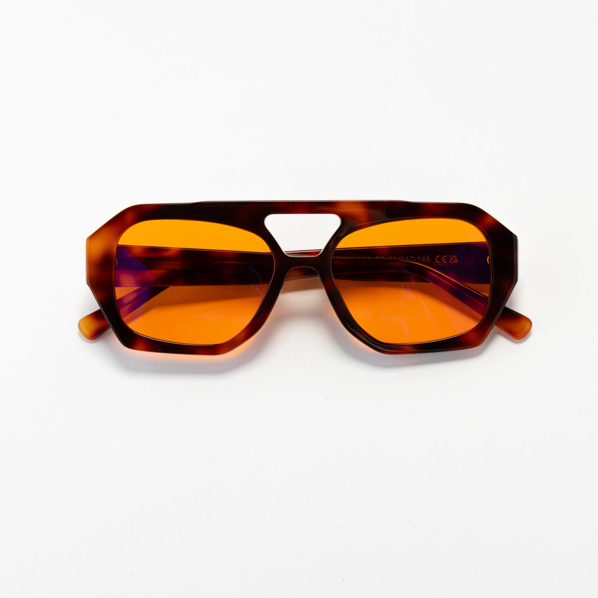 Good In Bed KAI blue light blocking glasses in Dark Tortoise with amber OFF DUTY lenses, product flat lay