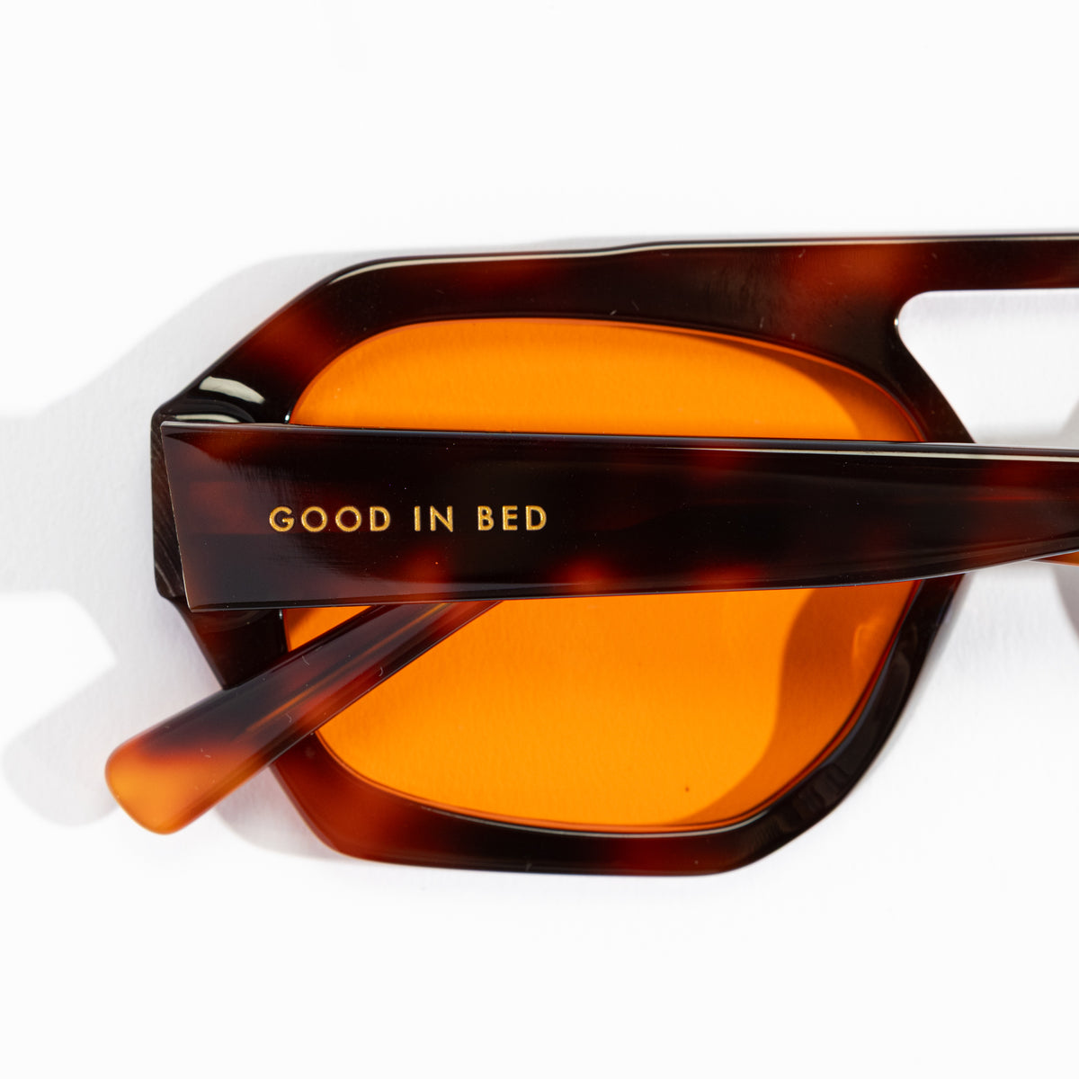 Close-up of Good In Bed KAI blue light blocking glasses Dark Tortoise frame showing brand name engraving on temple arm