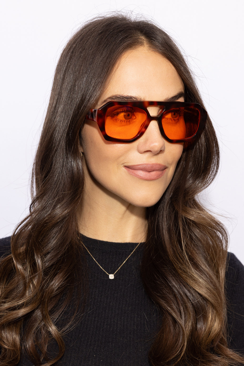 Woman wearing Good In Bed KAI blue light blocking glasses in Dark Tortoise, 3/4 profile lifestyle shot